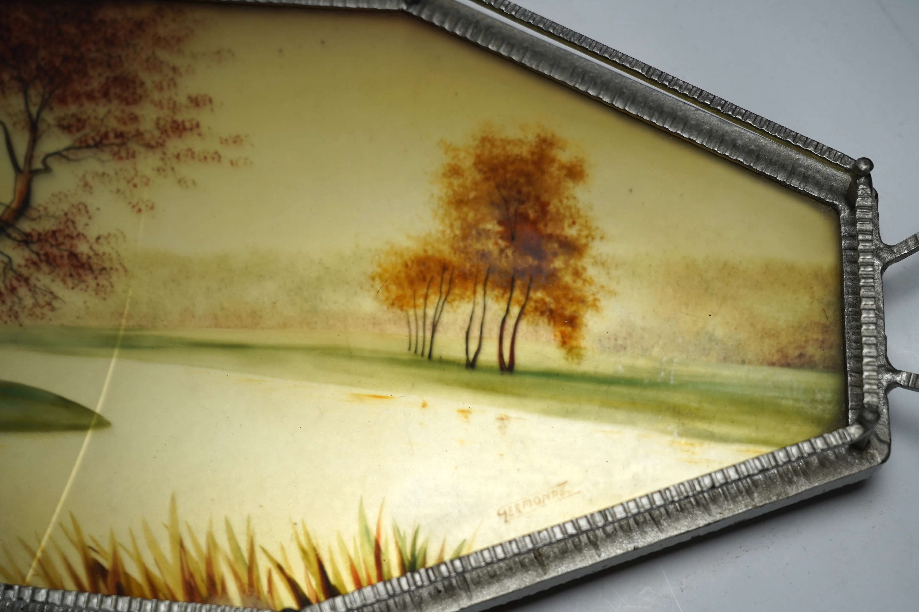 An Art Deco reverse painted and wrought iron tray, with a gallery, centered with a reverse painted landscape scene, signed 'Germonde', 70cm. Condition - damaged